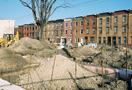 Row of houses with construction site in foreground. 