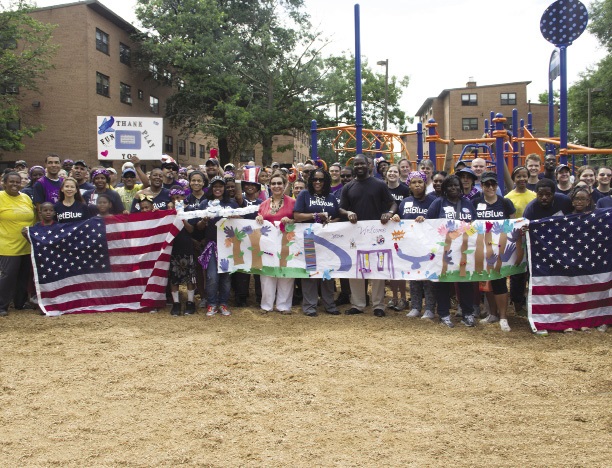 A large group of volunteers posing for a picture in the playground they’ve just built.