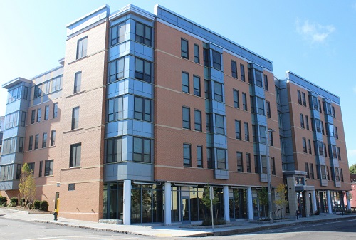 Exterior photograph of a five-story building, with storefronts on the first floor.