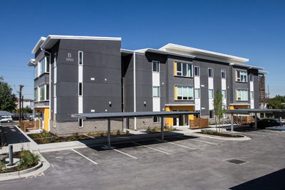 Photograph of a three-story multifamily building. 