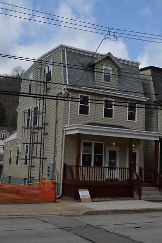 Photograph a three-story residential building in the process of being renovated.