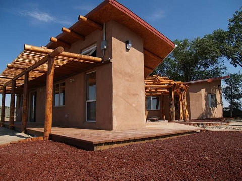 Exterior image of the Nageezi House, a single family detached home built using aerated flyash concrete block, and its attached shade structure.