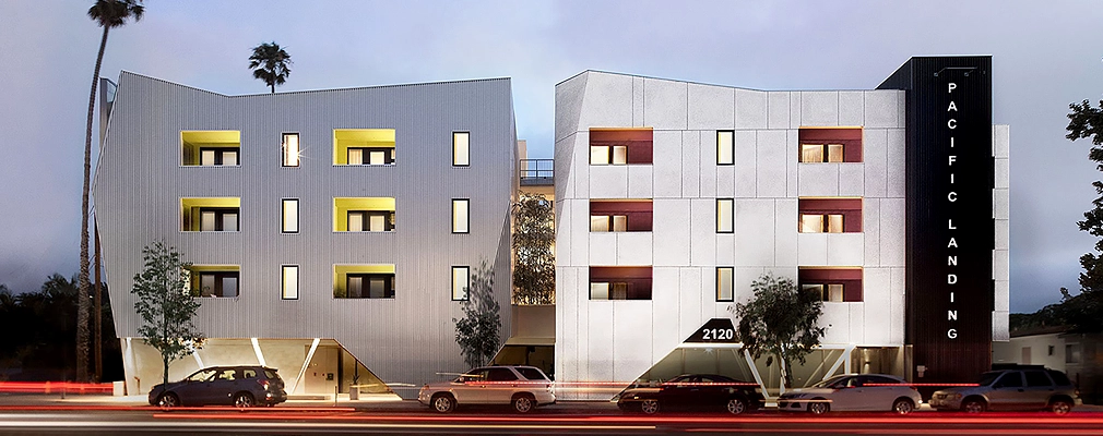 Four-story residential building with a sign reading “PACIFIC LANDING” written vertically in white letters on a black background.