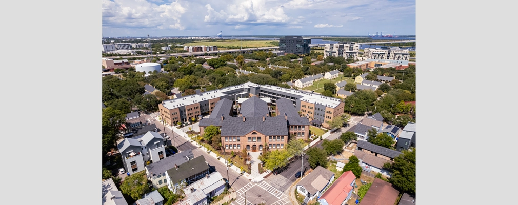 Aerial view of the former school and two adjoining three-story apartment buildings.