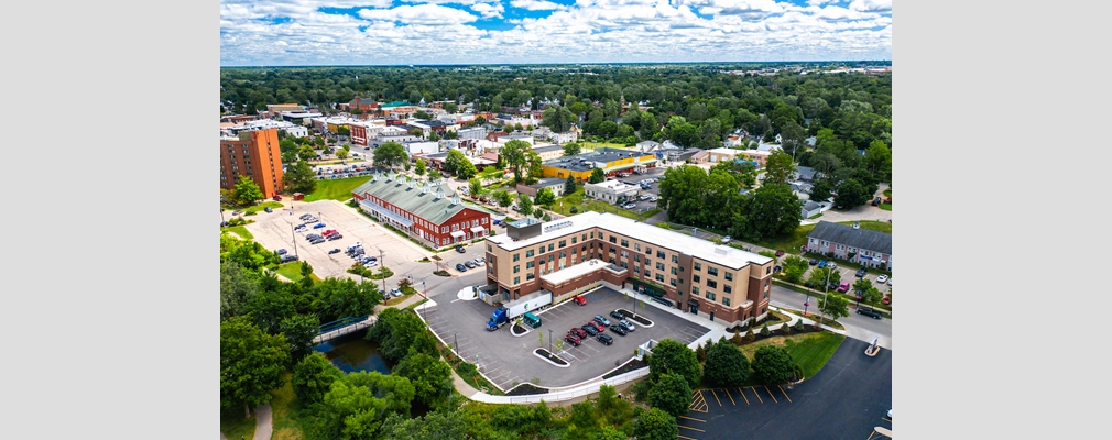 Aerial view of a small town with several low- and mid-rise buildings.