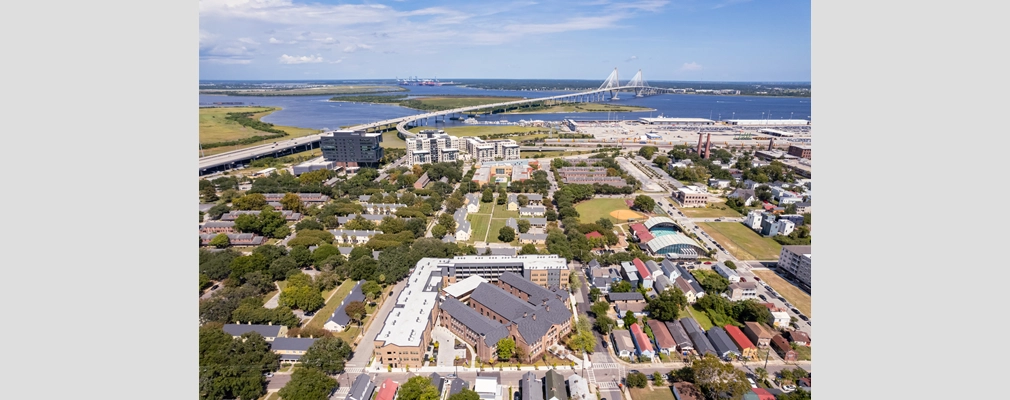 Ariel view of apartment buildings in an urban setting with Charleston’s iconic Cooper River Bridge in the background.