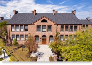 Restored two-story, red-brick school building.