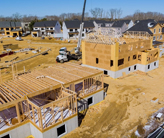 A construction site featuring wooden framing structures under development, showcasing the building process in progress.