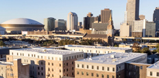 Five-story residential building with New Orleans skyline in the background.