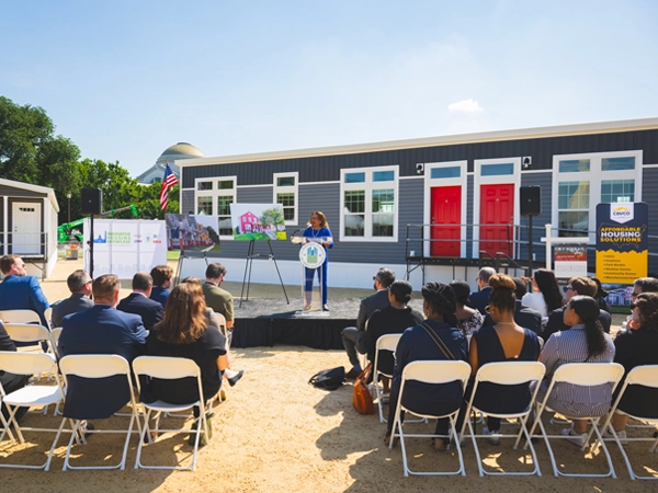 Acting Secretary of HUD Adrianne Todman providing opening remarks for the Innovative Housing Showcase in front of a model house.