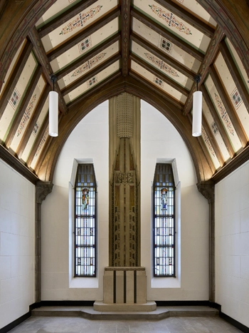 Small chapel with stained glass windows and a tall ceiling.