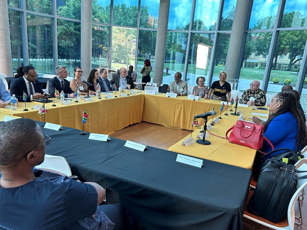 Attendees sitting at a table arranged in a square.