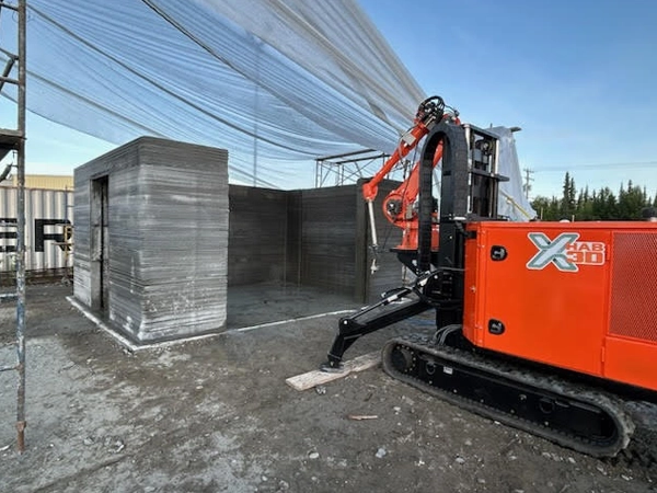 Image of a large 3D printer outdoors.