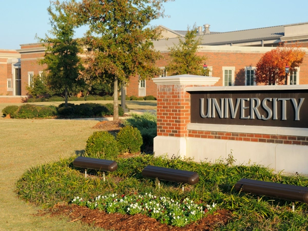 A building with a sign in front that says "University."