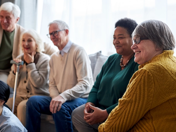 A group of smiling older adults sitting on a couch.